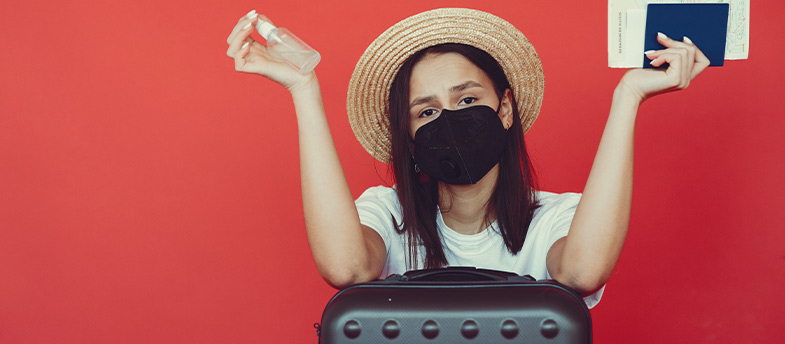 Woman holding a passport and wearing a mask